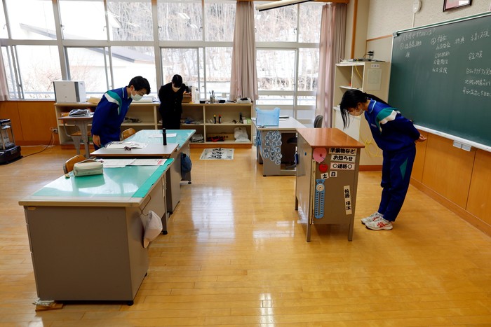 Eita Sato (first on the left), 15, and Aoi Hoshi (first on the right), 15, the only two students at Yumoto Junior High School, have their last school lunch with their teachers before their graduation and the institution's closing ceremony, Fukushima Prefecture, Japan, March 9, 2023. Eita and Aoi, who have been together since three, are the last two graduates of Yumoto Junior High, a public school established in 1947 that in its prosperous years sent out more than 50 graduates, but with only a few of enrolments expected in the coming years, the village decided to close the school for good. 