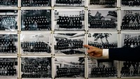 Kepala SMP Yumoto, Watanabe (54), menunjukkan foto-foto kelulusan angkatan lama sekolah itu, saat masih banyak siswanya. Karena angka kelahiran di Jepang anjlok lebih cepat dari yang diperkirakan, penutupan sekolah meningkat terutama di daerah pedesaan seperti Ten-ei, yang sudah berjuang dengan depopulasi.Kelahiran yang jatuh adalah masalah regional Asia, dengan biaya membesarkan anak mengurangi angka kelahiran di negara tetangga Korea Selatan dan China. Tetapi situasi Jepang sangat kritis. Foto: REUTERS/ISSEI KATO