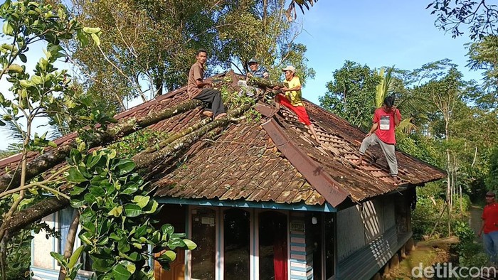 Warga membereskan rumah yang rusak di Purwakarta akibat angin kencang, Senin (3/4/2023).