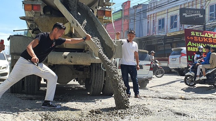 Aksi Bambang (32) kembali mengecor jalan rusak di Pekanbaru pakai dana pribadi. (Raja Adil Siregar/detikSumut)