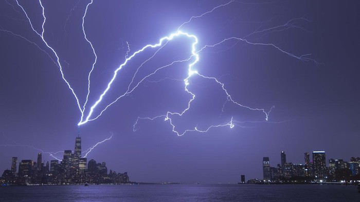 HOBOKEN, NJ - APRIL 1: Lightning bolts strike One World Trade Center in New York City as it fans out over the Hudson River and Jersey City, New Jersey during a thunderstorm on April 1, 2023, as seen from Hoboken, New Jersey.  (Photo by Gary Hershorn/Getty Images)