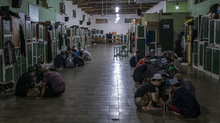 MAGETAN, INDONESIA - APRIL 03: Students perform prayers at the islamic boarding school Al-Fatah Temboro during the holy month of Ramadan on April 03, 2023 in Magetan, East Java, Indonesia. Al-Fatah Islamic Boarding School was founded in 1950 by KH. Kholid Umar, also known as Kyai Mahmud. Islamic boarding schools in Indonesia have around 22,000 students, including those from neighbouring countries in Southeast Asia, such as Malaysia, Brunei and Thailand. The Al-Fatah boarding school occupies a 50-hectare site in Temboro Village, Karas District, Magetan, East Java. It is the largest center for developing the ideology of the Tablighi Jamaat in Southeast Asia. The main goal of the Al-Fatah Islamic Boarding School is to learn about the Prophet, produce religious experts, spread Islam to all walks of life, improve oneself and uphold the da'wah journey of Allah's Apostle. The school's magnitude of the influence of religion on the lives of residents in Temboro has made this area known as the 'Village of Medina'. Students at the Pesantren, also known as 