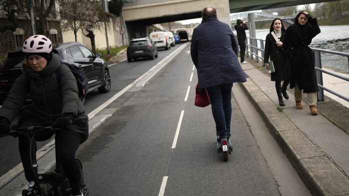 A man parks a scooter in Paris, Friday, march 31, 2023. Romantically zipping two-to-a-scooter, wind in the hair, past the Eiffel Tower and other iconic sights could soon become a thing of the past if Parisians vote Sunday to do away with the 15,000 opinion-dividing micro-machines. (AP Photo/Christophe Ena)