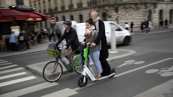 Paris Bakal Larang Skuter Listrik Mulai September A man parks a scooter in Paris, Friday, march 31, 2023. Romantically zipping two-to-a-scooter, wind in the hair, past the Eiffel Tower and other iconic sights could soon become a thing of the past if Parisians vote Sunday to do away with the 15,000 opinion-dividing micro-machines. (AP Photo/Christophe Ena)