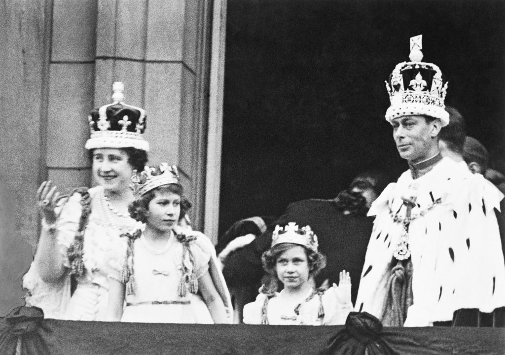 The crowned King George VI and Queen Elizabeth with Princess Elizabeth and Princess Margaret Rose, acknowledging the cheers of the crowd from the balcony of Buckingham Palace on their return from Westminster Abbey.