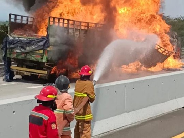 Petugas damkar memadamkan api truk angkut bahan kimia yang kecelakaan maut di Tol Pemalang, Selasa (4/4/2023).