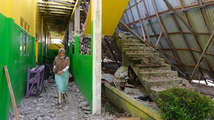 Ponpes di Kalbar Rusak Diterjang Angin Puting Beliung Seorang santriwati berjalan di bawah bangunan yang roboh diterjang angin puting beliung di Pondok Pesantren Madrasatul Quran di Sungai Rengas, Kabupaten Kubu Raya, Kalimantan Barat, Selasa (4/4/2023). Angin puting beliung yang terjadi pada Senin (3/4/2023) itu mengakibatkan bangunan asrama santriwati di ponpes tersebut roboh dan rusak berat. ANTARA FOTO/Jessica Helena Wuysang/foc.