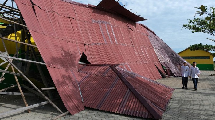 Ponpes di Kalbar Rusak Diterjang Angin Puting Beliung Seorang santriwati berjalan di bawah bangunan yang roboh diterjang angin puting beliung di Pondok Pesantren Madrasatul Quran di Sungai Rengas, Kabupaten Kubu Raya, Kalimantan Barat, Selasa (4/4/2023). Angin puting beliung yang terjadi pada Senin (3/4/2023) itu mengakibatkan bangunan asrama santriwati di ponpes tersebut roboh dan rusak berat. ANTARA FOTO/Jessica Helena Wuysang/foc.