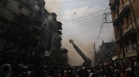 Tampak helikopter dan derek dikerahkan untuk memadamkan api. Anik Rahman/Getty Images