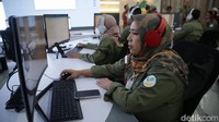 Para pekerja menggunakan peralatan canggih dalam pusat kendali ini.