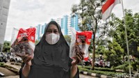 Seorang warga menunjukan daging sapi yang baru dibelinya dengan harga murah.