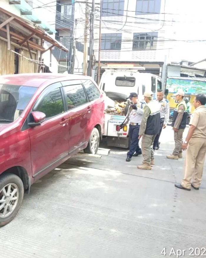 Video warga cekcok karena jalan umum di Jelambar, Jakbar dipakai untuk parkiran viral di medsos. Petugas menderek mobil yang ada di lokasi. (IG @kel.jelambarbaru)