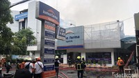 Sejumlah petugas pemadam melakukan sterilisasi sekitar lokasi kebakaran Apotek Kimia Farma di Jalan Diponegoro Surabaya saat proses pemadaman. Kebakaran apotek itu terjadi sekitar pukul 12.30 WIB. (Foto: Wisnu Setiadarma/detikJatim)