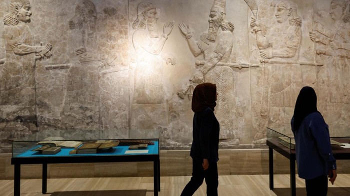 Visitors look at the Koran dating back to different periods of time, displayed for the first time in an exhibition during the holy month of Ramadan at the National Museum in Baghdad, Iraq April 4, 2023. REUTERS/Thaier Al-Su