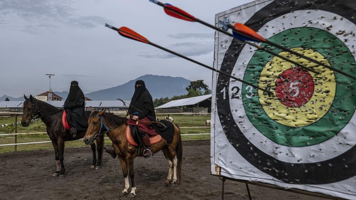 Melihat Santri di Kampung Madinah Jatim Memanah Sambil Berkuda MAGETAN, INDONESIA - APRIL 03: Annur and Nuraini, take part in horseback archery practice at the islamic boarding school Al-Fatah Temboro during the holy month of Ramadan on April 03, 2023 in Magetan, East Java, Indonesia. Al-Fatah Islamic Boarding School was founded in 1950 by KH. Kholid Umar, also known as Kyai Mahmud. Islamic boarding schools in Indonesia have around 22,000 students, including those from neighbouring countries in Southeast Asia, such as Malaysia, Brunei and Thailand. The Al-Fatah boarding school occupies a 50-hectare site in Temboro Village, Karas District, Magetan, East Java. It is the largest center for developing the ideology of the Tablighi Jamaat in Southeast Asia. The main goal of the Al-Fatah Islamic Boarding School is to learn about the Prophet, produce religious experts, spread Islam to all walks of life, improve oneself and uphold the da'wah journey of Allah's Apostle. The school's magnitude of the influence of religion on the lives of residents in Temboro has made this area known as the 'Village of Medina'. Students at the Pesantren, also known as