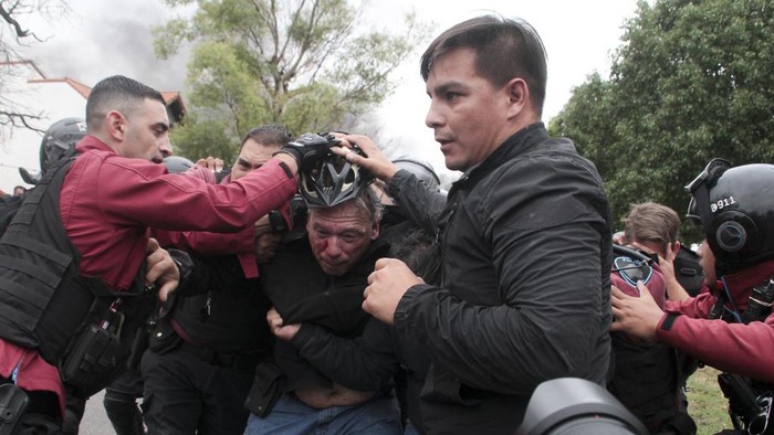 Sergio Berni, the security minister for the Buenos Aires province, center, is extracted from a protest in Buenos Aires, Monday, April 3, 2023. Berni was attacked during a protest by bus drivers after the murder of a co-worker while on the job. (AP Photo/Andres Pelozo)