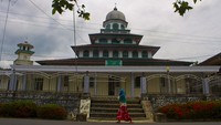 Warga berjalan di depan Masjid Al Ala, Desa Jatuh, Kabupaten Hulu Sungai Tengah, Kalimantan Selatan, Selasa (4/4/2023).  