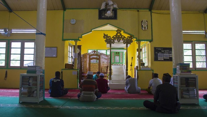 Warga berjalan di depan Masjid Al Ala, Desa Jatuh, Kabupaten Hulu Sungai Tengah, Kalimantan Selatan, Selasa (4/4/2023). Masjid yang dibangun sekitar abad ke-17 Masehi dan diperkirakan berumur lebih dari 300 tahun tersebut menjadi simbol dakwah islami di Kabupaten Hulu Sungai Tengah. ANTARA FOTO/Bayu Pratama S/nym.