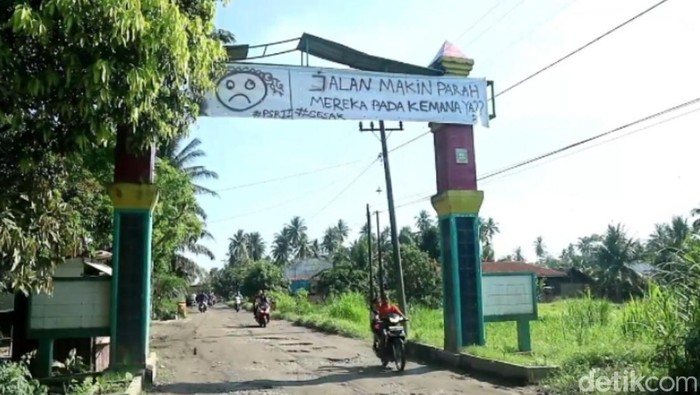Warga kembali pasang spanduk kekecewaan jalan rusak milik provinsi di Asahan yang sebelumnya pernah ‘dijual’.