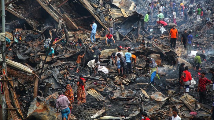 Mengais Sisa-sisa di Puing Kebakaran Pasar Baju Murah Bangladesh Fire-victim traders search for their merchandises, money and other valuables while smoke kept emanating from the charred ruins on Wednesday after a fire razes down Bangabazar shopping complex that housed several thousand shops at Phulbariai n Dhaka on April 05 , 2023. (Photo by Sony Ramany/NurPhoto via Getty Images)