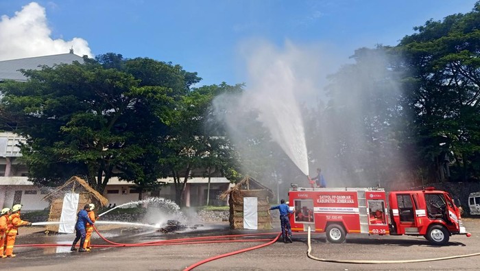Petugas pemadam kebakaran (damkar) Jembrana saat melakukan simulasi pemadaman kebakaran di area parkir GOR Kresna Jvara Jembrana, Kabupaten Jembrana, Kamis (6/4/2023).