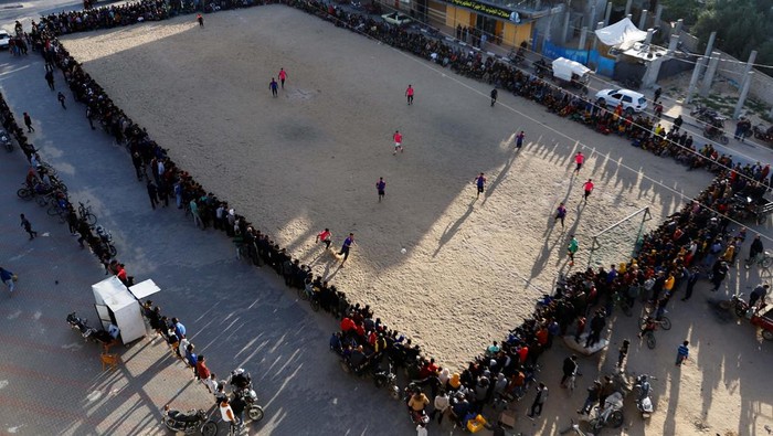 Young Palestinian men play football during the holy month of Ramadan, in Rafah in the southern Gaza Strip, March 31, 2023. REUTERS/Ibraheem Abu Mustafa