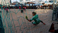 Pemuda Palestina bermain sepak bola selama bulan suci Ramadhan, di Rafah di selatan Jalur Gaza, 31 Maret 2023 lalu.