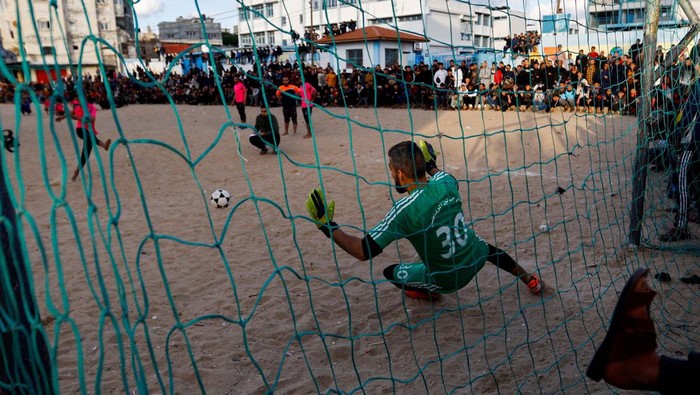 Sepakbola Jalanan, Jadi Ngabuburit Warga Rafah Palestina Young Palestinian men play football during the holy month of Ramadan, in Rafah in the southern Gaza Strip, March 31, 2023. REUTERS/Ibraheem Abu Mustafa