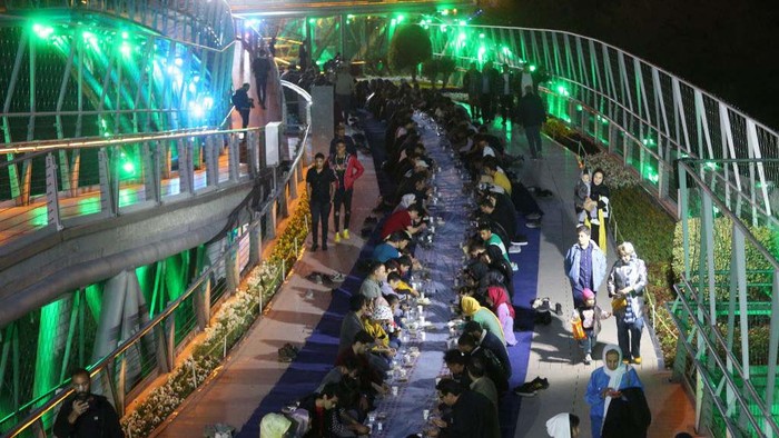TEHRAN, IRAN - APRIL 05: People have Iftar (fast-breaking) dinner prepared by the Tehran Municipality on Tabiat Bridge in Tehran, Iran on April 05, 2023. (Photo by Fatemeh Bahrami/Anadolu Agency via Getty Images)