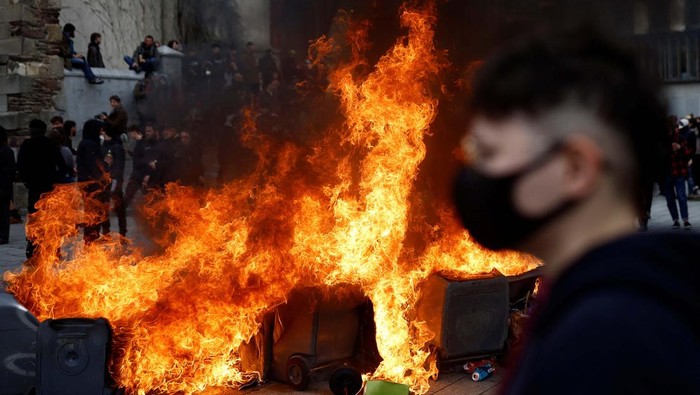 Aksi Tolak Reformasi Pensiun di Prancis Kembali Ricuh Masked protesters protect themselves with umbrellas near burning garbage bins amid clashes during a demonstration as part of the eleventh day of nationwide strikes and protests against French government's pension reform, in Rennes, France, April 6, 2023. REUTERS/Stephane Mahe