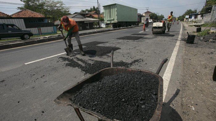Pekerja melakukan pengaspalan di jalur pantura Kandanghaur, Indramayu, Jawa Barat, Jumat (7/4/2023). Perbaikan jalur pantura tersebut ditargetkan selesai pada H-10 Lebaran. ANTARA FOTO/Dedhez Anggara/nym.