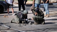 Petugas keamanan Israel memeriksa sisa-sisa roket di Shlomi, Israel.