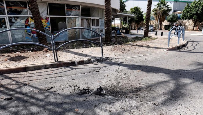 The remains of a rocket is seen stuck in the ground outside a damaged building of a bank, following incoming rockets from Lebanon to Israel in Shlomi, northern Israel April 6, 2023. REUTERS/Fadi Amun ISRAEL OUT. NO COMMERCIAL OR EDITORIAL SALES IN ISRAEL. NO RESALES. NO ARCHIVES