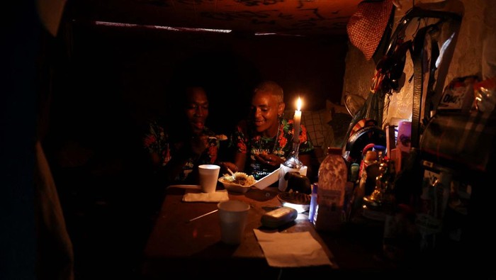 Thando Jansen and Romean September enjoy the hot meal they received during Iftar (breaking of the fast)  during the holy month of Ramadan at the site where Muslims and other organisations provide hot meals to the destitute and homeless in Cape Town, South Africa, April 6, 2023. REUTERS/Esa Alexander