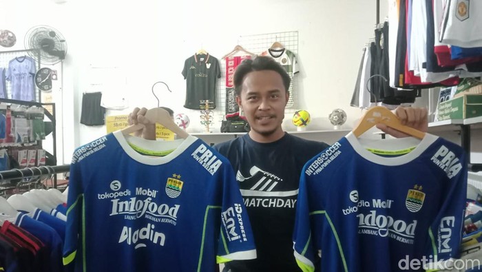 Oktavian (30) memperlihatkan jersey Persib player issue dan supporter edition di tokonya di Cijerah