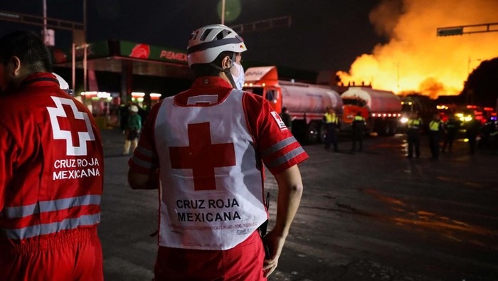 People watch the fire at the Central de Abastos wholesale market in Mexico City, Mexico April 6, 2023. REUTERS/Luis Cortes
