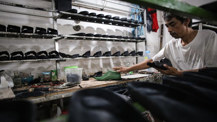 PRODUKSI SANDAL KULIT DI MOJOKERTO Pekerja menyelesaikan pembuatan sandal di industri sandal rumahan Mojokerto, Jawa Timur, Jumat (7/4/2023). Produksi sandal berbahan kulit asli dan sintetis yang dijual dengan harga Rp120 ribu hingga Rp165 ribu per pasang tersebut meningkat hingga 40 persen dari 250 pasang per hari pada hari biasa menjadi 400 pasang per hari untuk memenuhi permintaan pada bulan Ramadhan. ANTARA FOTO/Rizal Hanafi/Ds/foc.