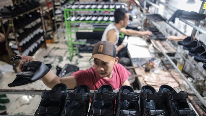 Pekerja menyelesaikan pembuatan sandal di industri sandal rumahan Mojokerto, Jawa Timur, Jumat (7/4/2023). Produksi sandal berbahan kulit asli dan sintetis yang dijual dengan harga Rp120 ribu hingga Rp165 ribu per pasang tersebut meningkat hingga 40 persen dari 250 pasang per hari pada hari biasa menjadi 400 pasang per hari untuk memenuhi permintaan pada bulan Ramadhan. ANTARA FOTO/Rizal Hanafi/Ds/foc.