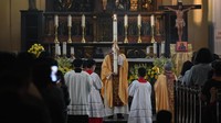 Momen saat petugas gereja membawa lilin dalam Misa Malam Paskah.