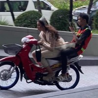 Kehadirannya dengan motor tentu mengejutkan karena tidak biasanya seorang wanita yang sudah berdandan cantik memilih transportasi tersebut. Dalam video, orang-orang yang melihatnya pun bersorak-sorak mengagumi kemampuannya menyetir motor. Dikatakan jika supir aslinya adalah pria yang duduk di belakang yang juga mengabadikan momen langka itu dengan ponselnya.Foto: Instagram Ninew Anuthida