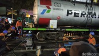 Proses evakuasi dilakukan petugas KAI terhadap 2 gerbong KA BBM yang anjlok, rodanya keluar dari jalur rel. As roda gerbong itu satu persatu dikembalikan ke jalur dengan menggunkan pompa hidrolik. (Foto: Suparno/detikJatim)