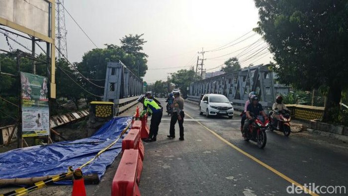 Sejumlah polisi menyiapkan water barrier untuk penutupan total jembatan mulai Sabtu malam nanti.