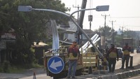 Pekerja menyelesaikan pemasangan lampu Penerangan Jalan Umum (PJU) di Jalur Pantura Losarang, Indramayu, Jawa Barat, Minggu (9/4/2023).