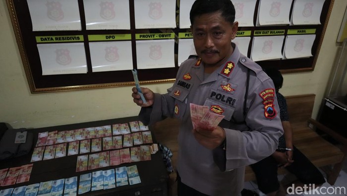 Kapolsek Purwokerto Timur, AKBP Sambas Budi Waluyo menunjukkan barang bukti uang palsu yang disita dari PS saat diedarkan di Pasar Minggon kompleks GOR Satria Purwokerto, Minggu (9/4/2023).