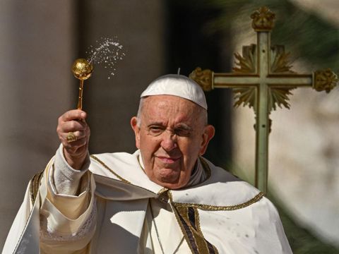 Paus Fransiskus memerciki hadirin dengan air selama misa Minggu Paskah pada 9 April 2023 di lapangan Santo Petrus di Vatikan, sebagai bagian dari perayaan Pekan Suci. (ANDREAS SOLARO/AFP via Getty Images)