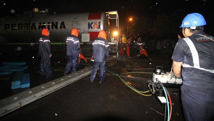 Potret Evakuasi Gerbong KA BBM yang Anjlok di Sidoarjo Petugas mengevakuasi rangkaian gerbong kereta api (KA) ketel atau pengangkut BBM yang anjlok di pelintasan Jalan Raya Bebekan, Sepanjang Taman, Sidoarjo, Jawa Timur, Sabtu (8/4/2023). Kereta Api barang angkutan BBM 2636 mengalami anjlok 6 AS pada rangakian 4 sebanyak 2 AS dan nomor 5 sebanyak 4 AS. ANTARA FOTO/Umarul Faruq/aww.