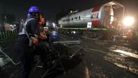 Petugas mengevakuasi rangkaian gerbong kereta api (KA) ketel atau pengangkut BBM yang anjlok di pelintasan Jalan Raya Bebekan, Sepanjang Taman, Sidoarjo, Jawa Timur, Sabtu (8/4/2023).