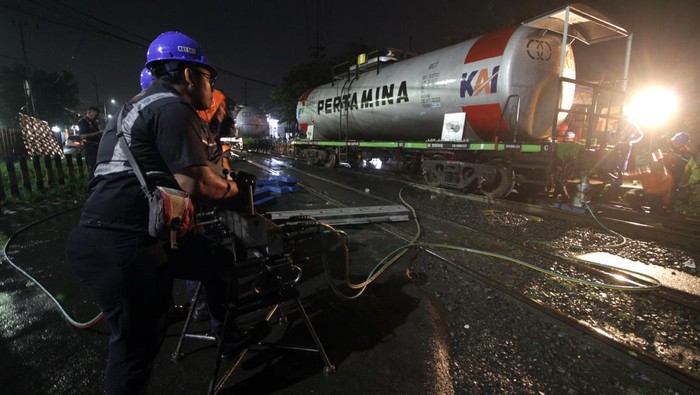 Potret Evakuasi Gerbong KA BBM yang Anjlok di Sidoarjo Petugas mengevakuasi rangkaian gerbong kereta api (KA) ketel atau pengangkut BBM yang anjlok di pelintasan Jalan Raya Bebekan, Sepanjang Taman, Sidoarjo, Jawa Timur, Sabtu (8/4/2023). Kereta Api barang angkutan BBM 2636 mengalami anjlok 6 AS pada rangakian 4 sebanyak 2 AS dan nomor 5 sebanyak 4 AS. ANTARA FOTO/Umarul Faruq/aww.