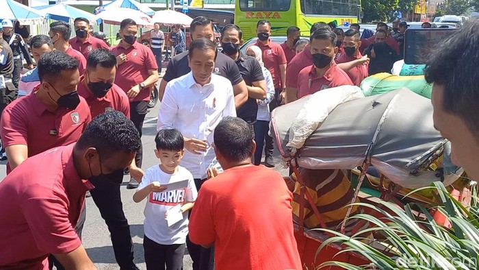 Presiden Joko Widodo (Jokowi) dan cucunya, Jan Ethes memberikan bantuan kepada sejumlah pedagang, tukang parkir, dan tukang becak di Solo, Minggu (9/4/2023).