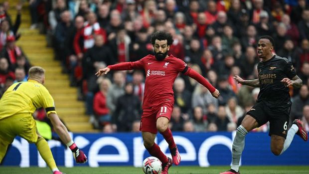 Liverpool's Egyptian striker Mohamed Salah (C) runs to shoot wide of Arsenal's English goalkeeper Aaron Ramsdale during the English Premier League football match between Liverpool and Arsenal at Anfield in Liverpool, north west England on April 9, 2023. (Photo by Paul ELLIS / AFP) / RESTRICTED TO EDITORIAL USE. No use with unauthorized audio, video, data, fixture lists, club/league logos or 'live' services. Online in-match use limited to 120 images. An additional 40 images may be used in extra time. No video emulation. Social media in-match use limited to 120 images. An additional 40 images may be used in extra time. No use in betting publications, games or single club/league/player publications. /  (Photo by PAUL ELLIS/AFP via Getty Images)